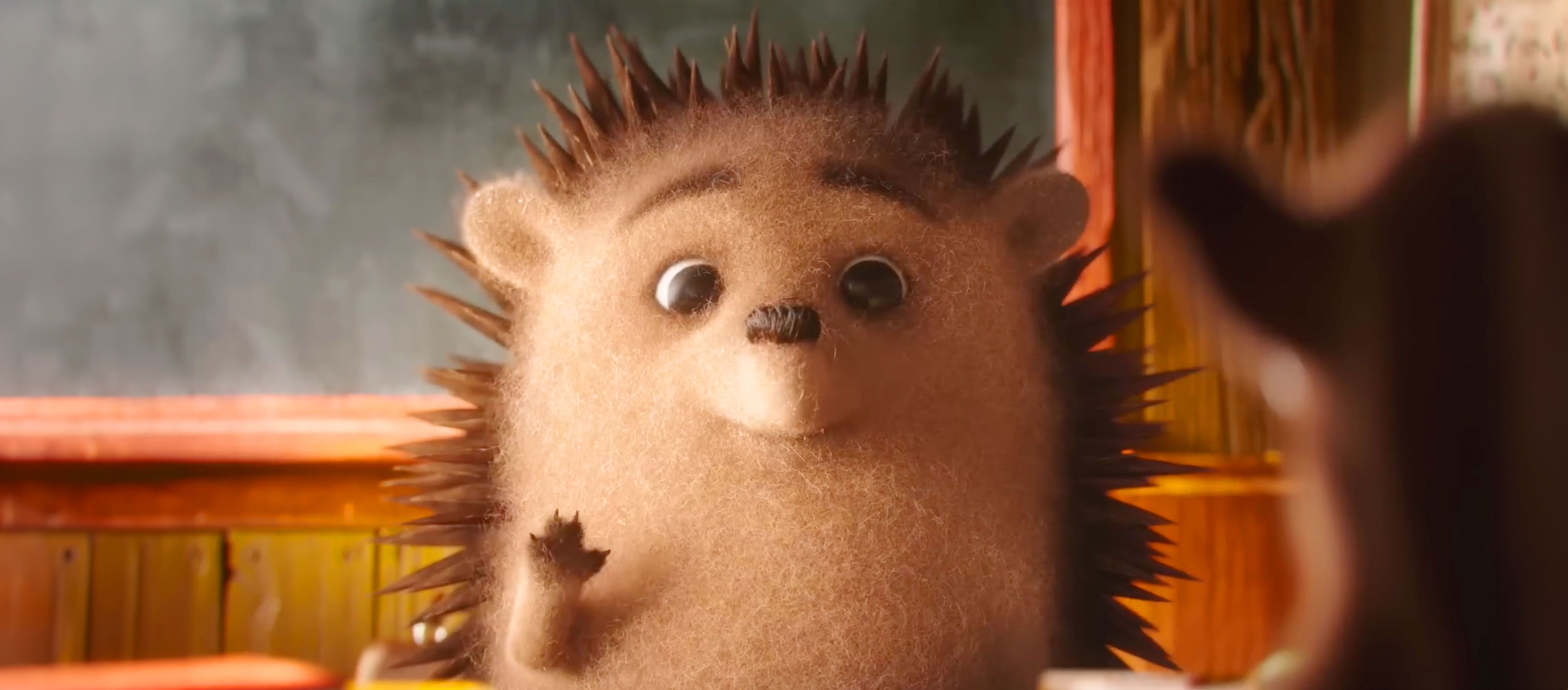 Der Igel von der #glaubanweihnachten Video Kampagne winkt lächelnd.